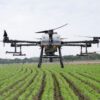 DJI Agras T30 price package including a 30-liter agricultural spraying drone unfolded over a farmland field.